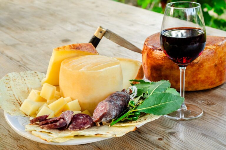 Tray of typical sardinian salami and pecorino with a glass of red cannonau wine, italian food, european gastronomy